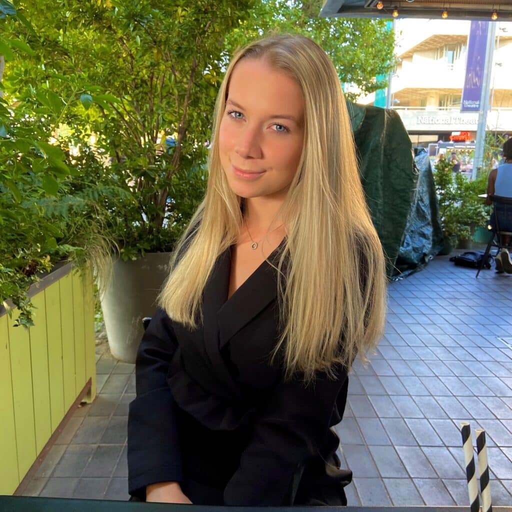 an image of Abbey from Samdai posing in a black shirt against a green plant