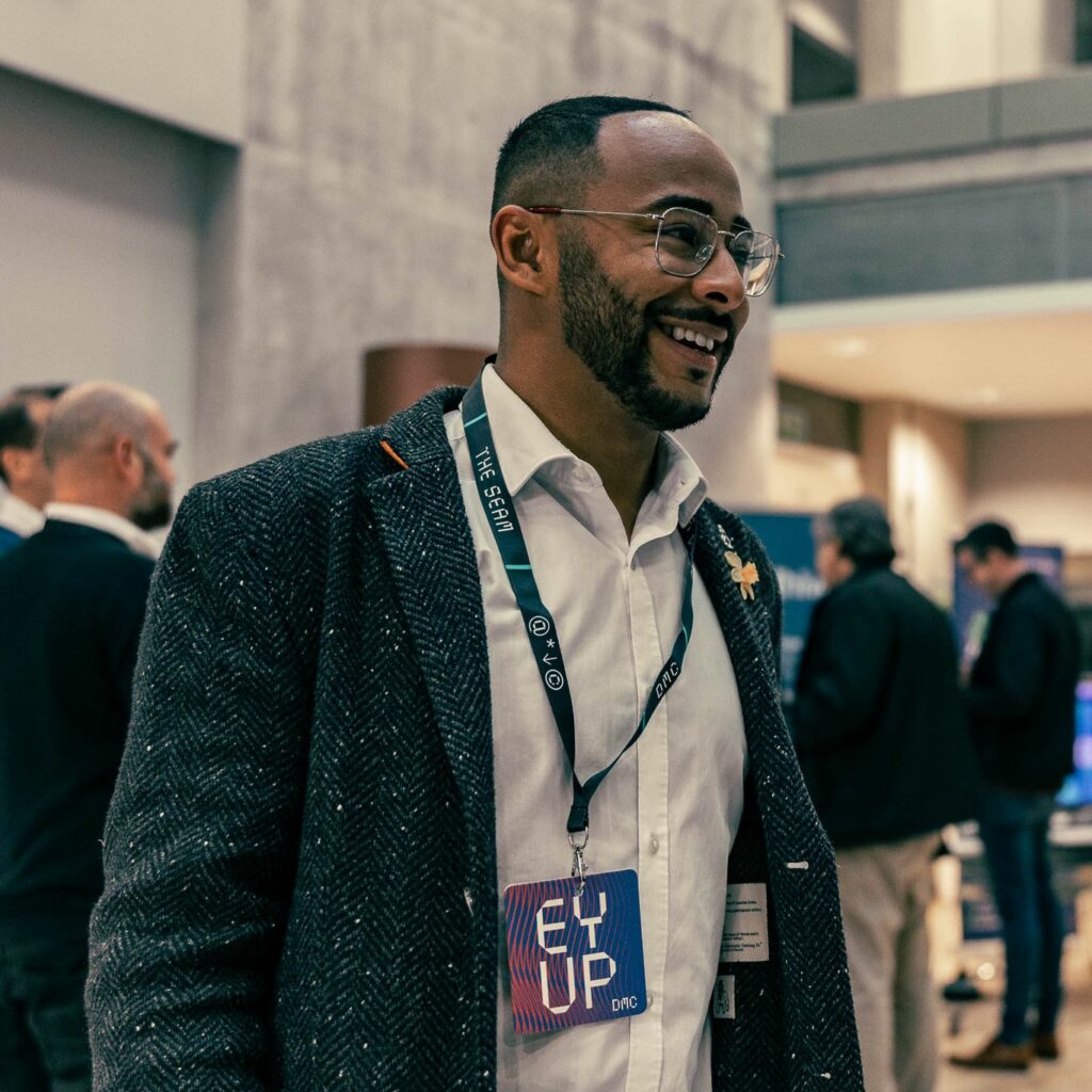 Darren Forde from Samdai smiling with a lanyard around his neck at a business networking event
