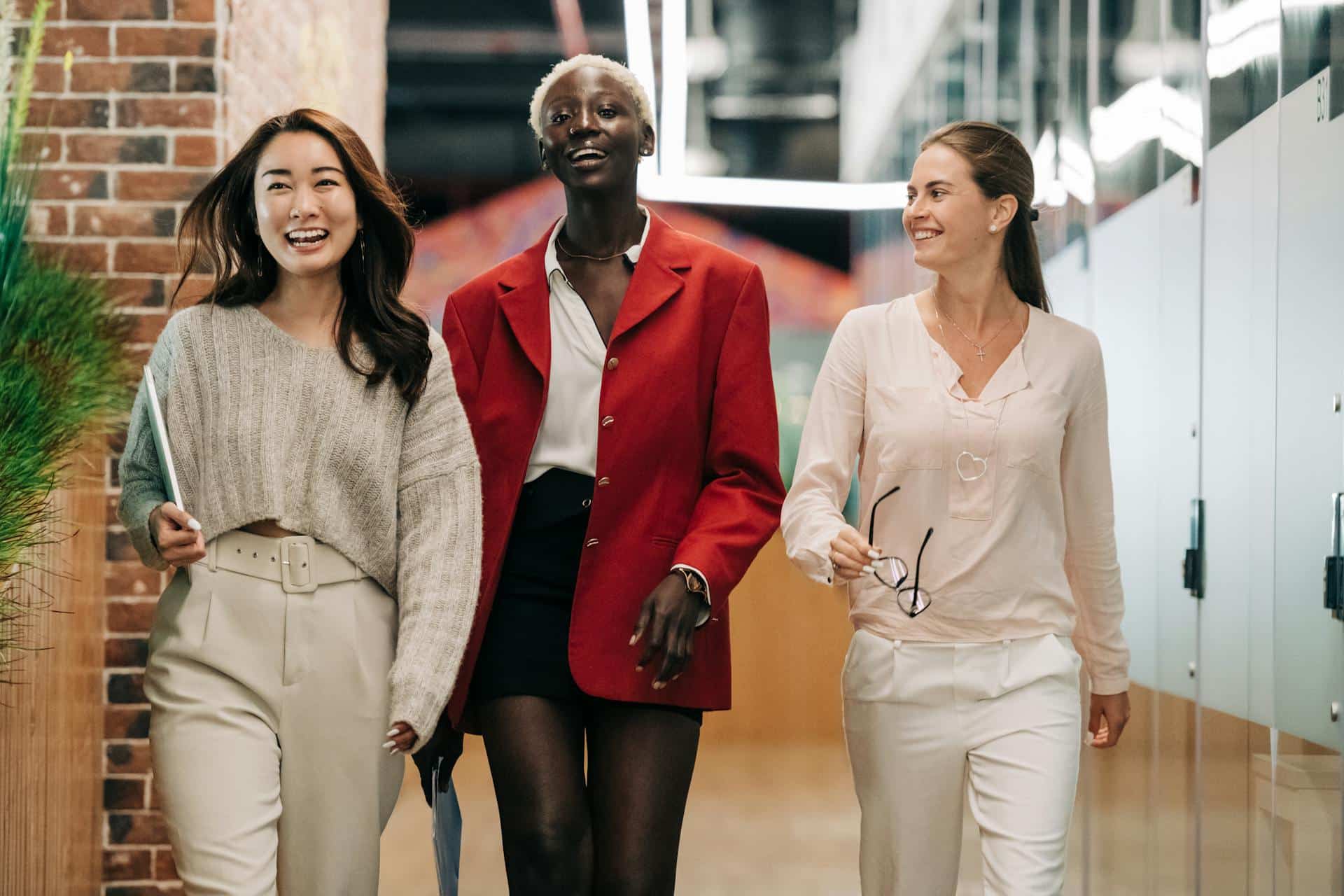 A group of 3 business women walking and smiling
